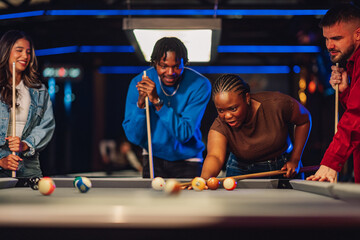 Diverse friends enjoying playing pool at a bar, laughing and having fun during a lively evening competition © Zamrznuti tonovi