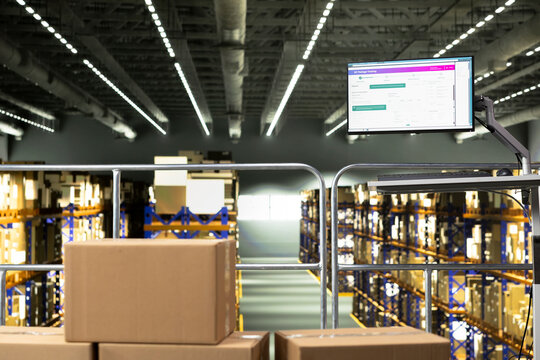 No people in warehouse storage facility with computer showing parcel tracking software on fulfillment center platform. Visible shipment details and tracking numbers highlight cargo handling.