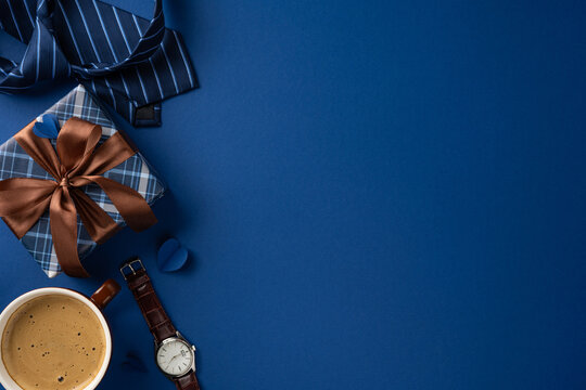 Father's Day gift flat lay with watch, tie, coffee and blue wrapped present