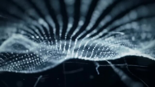 Mesmerizing video of undulating wave of luminous white, icy-blue particles flowing across deep charcoal, indigo digital void with subtle grid, high-tech data stream concept