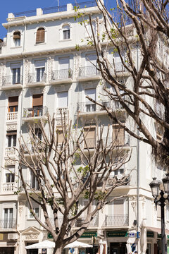 wide angle city corner scene in Russafa, Valencia, with apartments and cafes on a sunny day