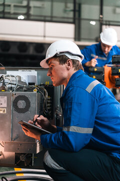 Repair specialist inspects machinery in factory ensuring industry standards with spare parts for maintenance and safety compliance in modern industrial environment