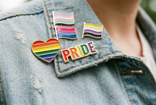 Macro view of pride transgender bisexual and nonbinary flag pins attached to denim jacket collar for lgbtq identity visibility. Pride month. LGBT equality and diversity. Love is love with copy-space.