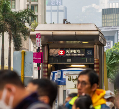 Hong Kong, China, 8 March 2026: entrance of Tsim Sha Tsui station with bilingual signage and urban crowd in foreground, iconic metro access in dense Kowloon district