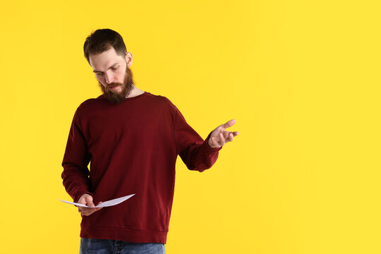 Professional actor with script performing on yellow background