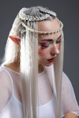 Naklejka premium Beautiful girl dressed as elf on grey background