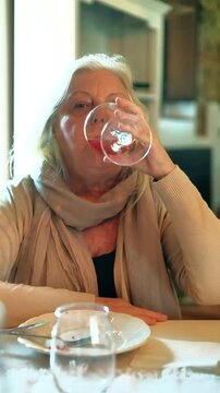 A woman drinks a glass of ros&eacute; wine. The woman is seventy years old, although she looks younger, and has long blond hair. The woman's toast is a reminder of the serenity and pleasure of company