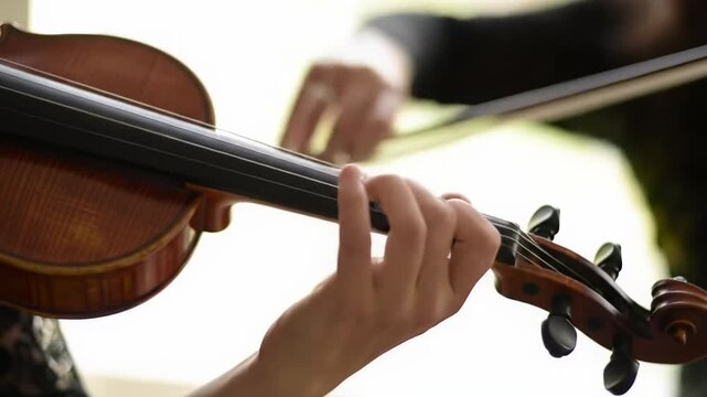 Tight macro video: classical violinist's hands, fingers pressing strings, bow gliding. Soft natural light, creamy bokeh, immersive musical precision and mastery
