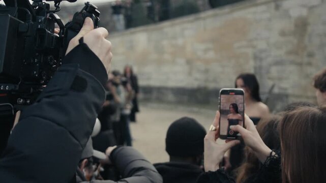 Paparazzi and fans photographing celebrity on the red carpet event