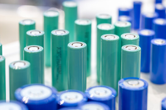Rows of turquoise and blue lithium-ion rechargeable batteries 18650. High-quality cylindrical cells for power tools and electric vehicles. Professional industrial energy storage solutions