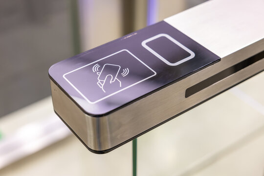 Electronic access control panel for smart card authentication on glass gate. Modern security entrance system for office building and corporate facilities. High tech rfid reader device