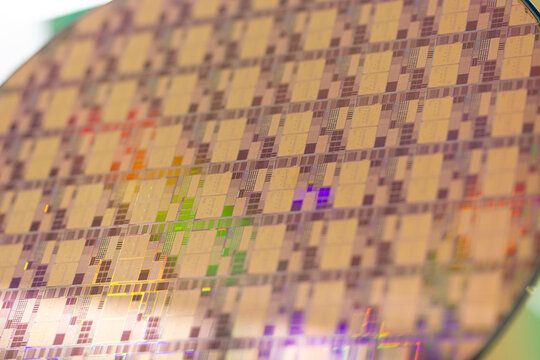Detailed view of a semiconductor silicon wafer with iridescent light reflections. Advanced microchip manufacturing. Microelectronics integrated circuit patterns in macro photography