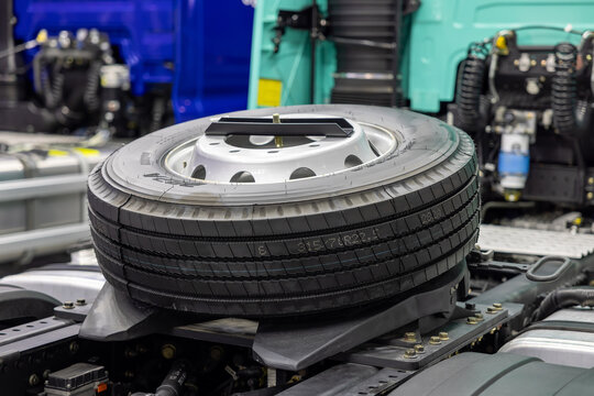 Fifth wheel coupling and spare tire on a modern truck tractor chassis. Heavy duty towing equipment for semi trailer logistics. Industrial automotive components and transport detail