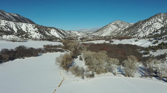 Aerial view of Grass Valley and Hogback Ridge in Garfield County, Colorado after heavy snowfall on cold clear February morning 4K.