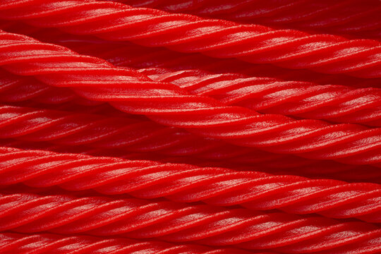 A top down view of a pile of red licorice sticks, as a background.