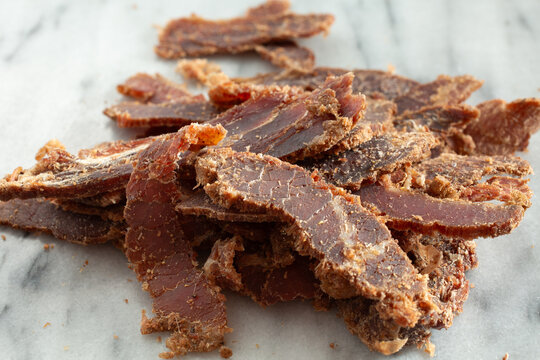 A closeup view of a pile of thin slice steak snack.