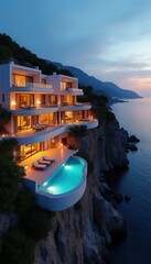 Obraz premium Modern cliffside villa with infinity pool overlooks ocean at dusk. Multi-story luxury home features balconies, lounge chairs, and scenic sea views. Elegant architecture blends with natural landscape.