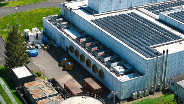 Aerial view of a data centre featuring solar panels on the roof, industrial cooling systems, and ventilation fans Wellingborough, England, United Kingdom.