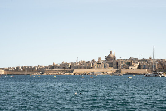 Horizontal view of Valletta skyline with Basilica of Our Lady of Mount Carmel. Historic limestone bastions and sea in Malta.
