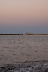 Naklejka premium Epic sunset resort sea wave stone breakwater lighthouse vertical panorama background. 