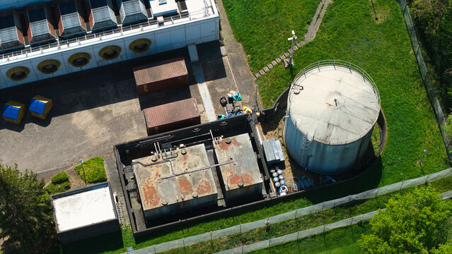 Aerial view of the industrial infrastructure of a data centre featuring storage tanks, cooling systems, and shipping containers surrounded by green lawns Wellingborough, England, United Kingdom.