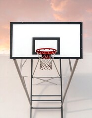 Naklejka premium View from below of a basketball hoop mounted outdoors against a white wall with a peach-colored sky