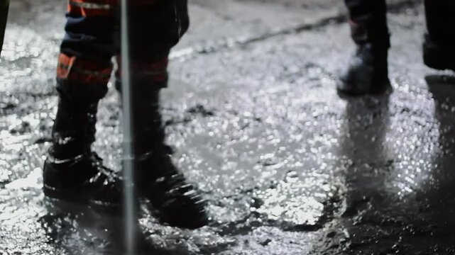 Professional cleaner using a hydro blaster to wash a dirty concrete floor in an industrial warehouse