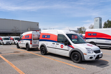 Fototapeta premium Toronto, Canada - April 26, 2026: Canada Post delivery vehicles parked in a parking lot at a Post office in Toronto, Canada. Canada Post is a Crown corporation owned by the federal government. 