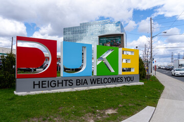 Naklejka premium Toronto, Canada - May 1, 2026: The DUKE Heights Business Improvement Area (BIA) welcome ground sign located on Finch Avenue in North York, Ontario, Canada, featuring large, colorful letters. BIA is a