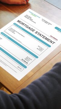 A Stressed Out Homeowner Looks at a Past Due Generic Mortgage Statement - Vertical