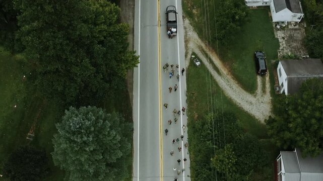 Top down aerial view of a platoon of soldiers on a training march along a country road