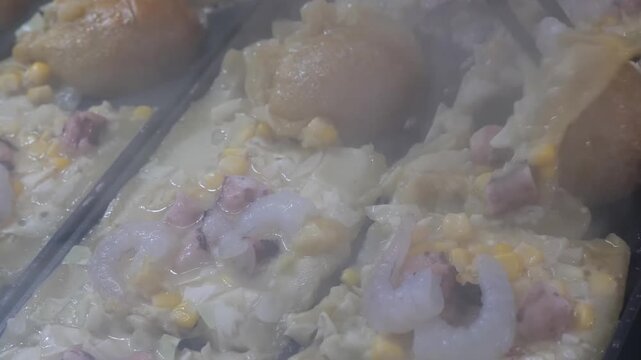 Close-up footage of a delicious, authentic Sipo Egg dish, a classic Kapampangan specialty from the Philippines. The footage highlights the rich, creamy texture of the white sauce as it coats fresh shr
