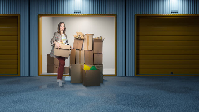 Self storage, moving service. Woman organizes and carries cardboard boxes in storage unit, preparing belongings for relocation and packing household items.