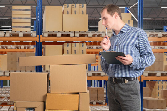 Warehouse management, supervisor checks cardboard boxes with clipboard near storage racks, planning inventory control and shipment organization.
