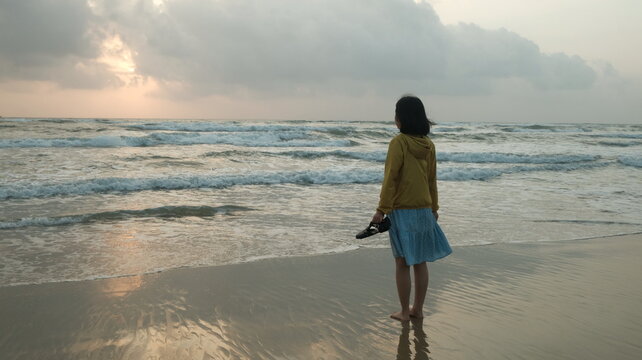 Young Woman Standing At Beach Sunrise