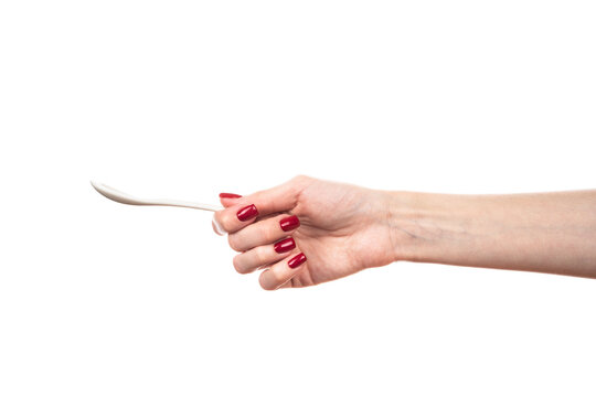 White ceramic tea spoon in female hand isolated on white background.