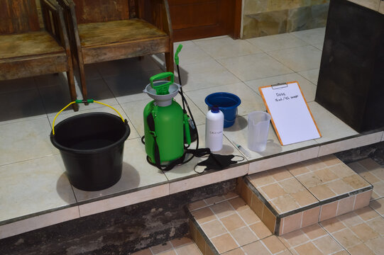 Extreme high angle perspective of a calcium fertilizer mixing station. Displays the 15ml per 5L dosage ratio with a pressure sprayer and measuring tools for preventive plant maintenance.