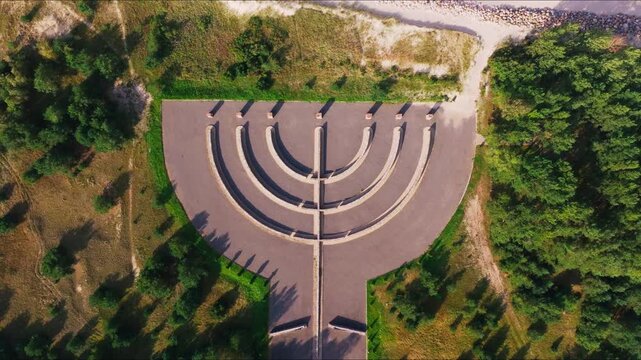Aerial pullback shows symbolic monument blending nature history, Liepaja