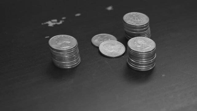 Black and white look of placing a neat stack of quarters.