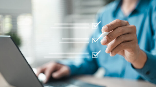 Business professional using laptop and stylus with digital checklist interface, representing task management, online survey, approval process, planning, review, evaluation and workflow productivity.