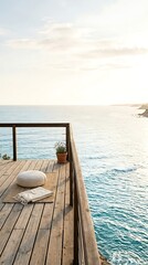 Obraz premium Serene wooden deck overlooking the ocean at sunrise, a peaceful spot for meditation and relaxation with soft cushions and a potted plant.