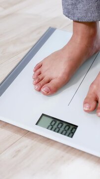 Person Stepping on Digital Bathroom Scale to Check Body Weight