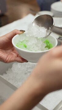 Adding Shaved Ice to Thai Lod Chong Dessert in White Bowl
