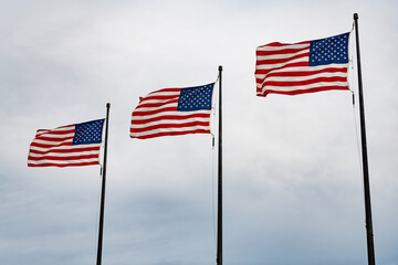Obraz premium American Flag for Memorial Day or 4th of July. American flag waving in the wind. Flag of the USA. National waving flag of united states on blue sky. Independence day. Patriotic symbol