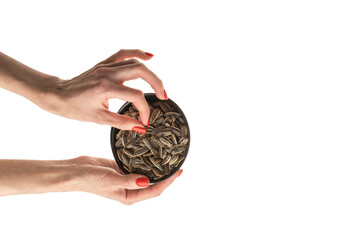 Naklejka premium Female hand sunflower seeds on a white background isolation