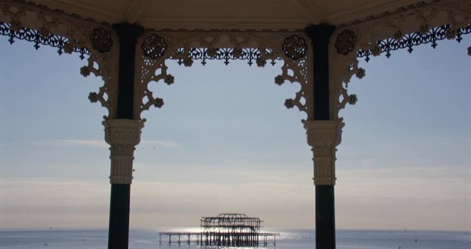 Extra Wide Tilting down shot of the Brighton Beach Bandstand with Dialect Brighton West pier in background,
