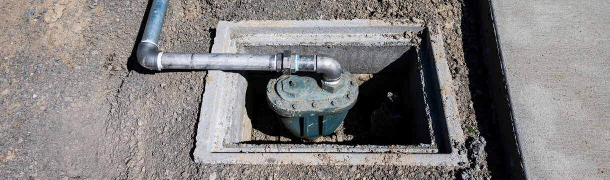 Water Utility Meter installed in a precast concrete underground vault with metal pipe rising out it with a brass filter on the end, new residential development construction project 
