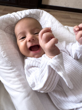 Smiling newborn baby on soft white pillow at home portrait