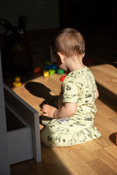 Toddler playing with toys on sunlit floor at home