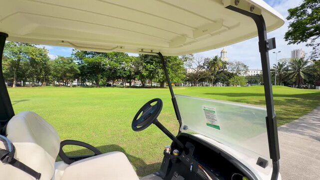 Golf Cart Driving Across a Green Fairway in Manila